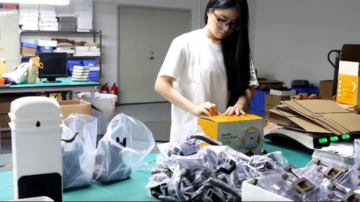 CHEETA team member packing an audio guestbook phone into its retail box